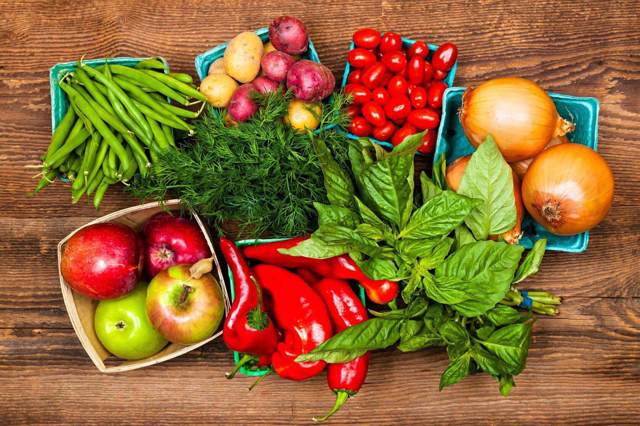 A wooden table topped with lots of fresh produce.
