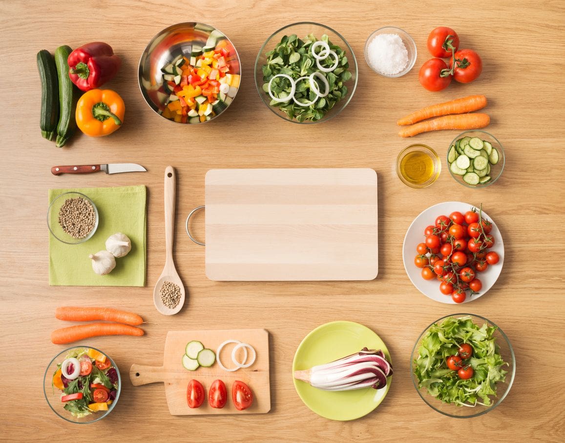 A wooden table topped with lots of different vegetables.